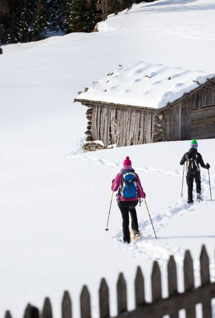 Schneeschuhwanderer laufen zur Hütte in den Alpen in Meran
