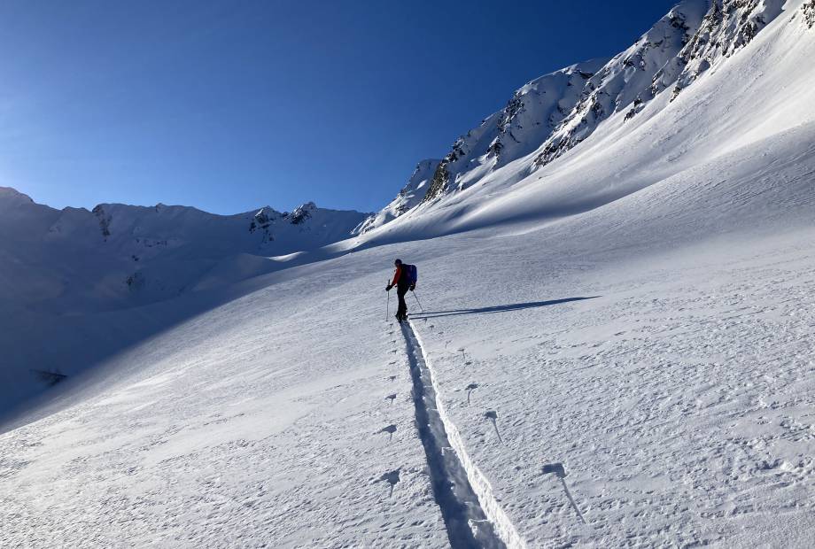 Mann wandert im Schnee in den Alpen in Südtirol
