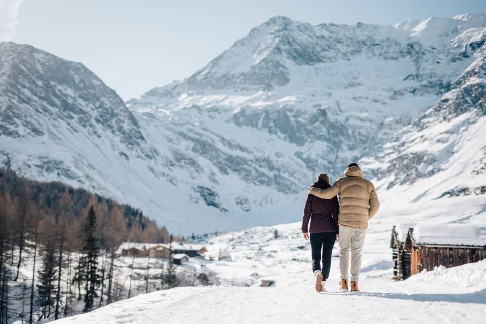 Paar spaziert im Schnee in den Südtiroler Alpen